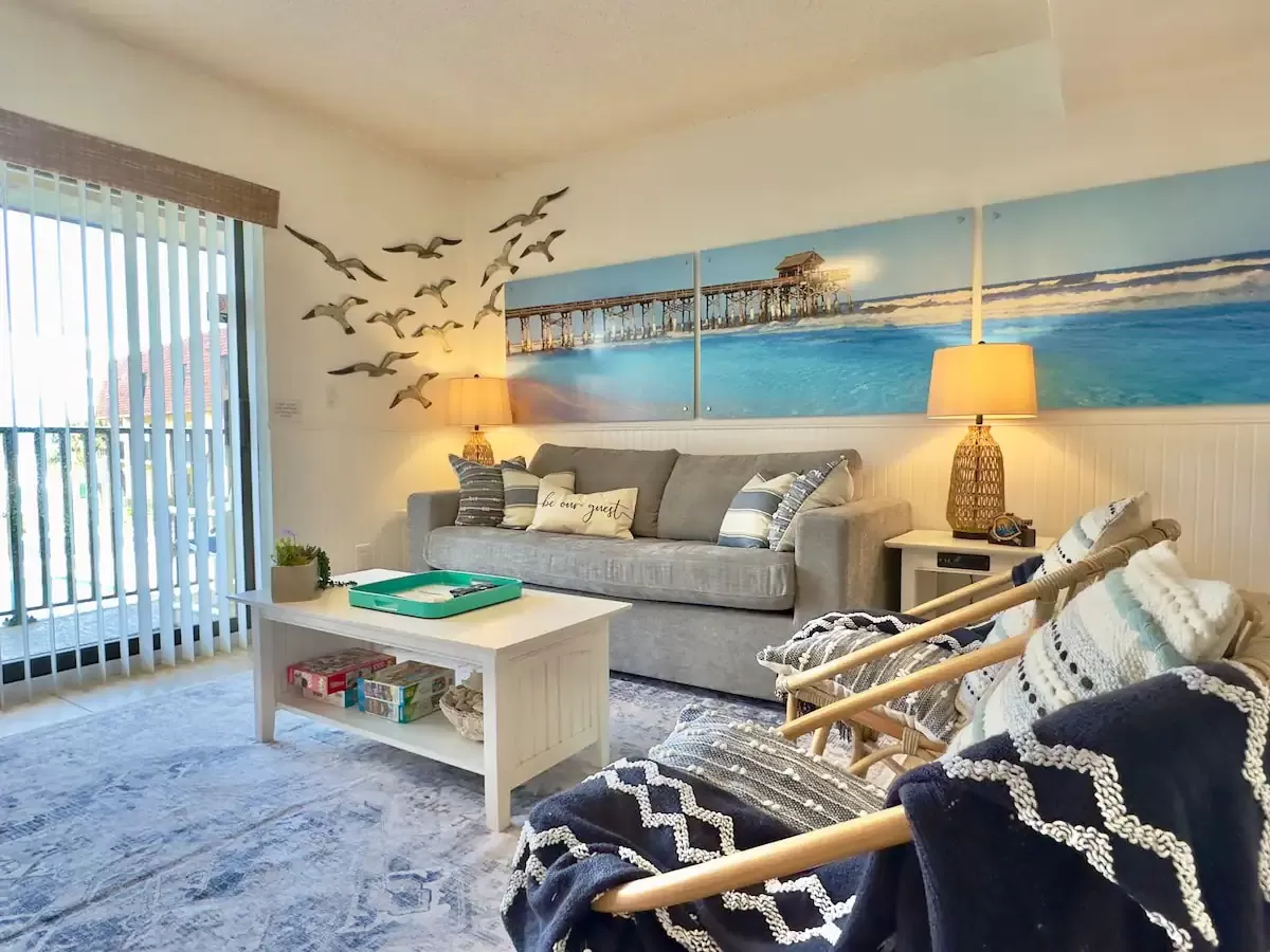 Enjoy the open living area with views of the pool and the ocean out the balcony sliding doors.